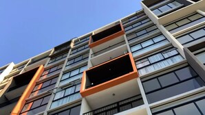 Un immeuble à plusieurs étages doté de balcons et de grandes fenêtres.