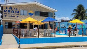 Ein Restaurant direkt am Strand mit Außenbereich und Wandgemälde.