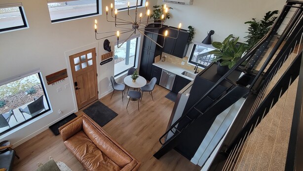 Un interior moderno con comedor, cocina y escalera.