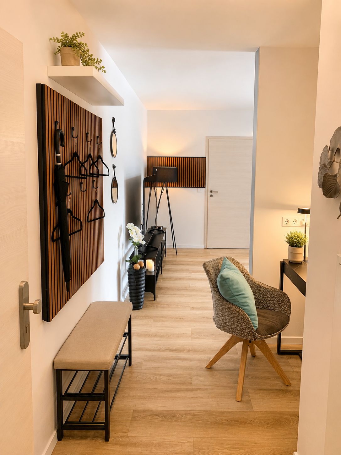 Un interno moderno con pavimento in legno, una panca, una sedia con cuscino, un attaccapanni a parete e una lampada da terra.