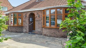 Ein zweistöckiges Haus mit Ziegelaußenwand, großen Fenstern und einem Ziegeldach.