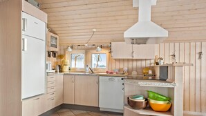 A modern kitchen with wooden cabinets, a built-in dishwasher, and a window providing natural light. - Nice home in Frøstrup with sauna (Frøstrup)
