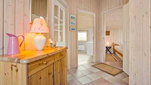 A wooden interior with a kitchen counter, a lamp, and a bed in the adjacent room. - Nice home in Frøstrup with sauna (Frøstrup)