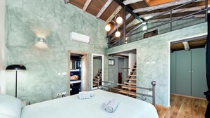 A spacious bedroom with a large bed, a walk-in closet, and a staircase leading to an upper level. - Amazing home in Kanfanar (Kanfanar)