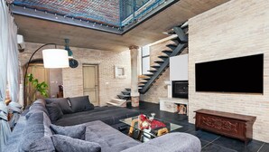 A modern living room with a sectional sofa, a glass coffee table, a TV, and a staircase. - Amazing home in Kanfanar (Kanfanar)