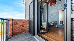 A modern room with a wooden floor, a bed with a white bedspread, a small table, and a chair. - Amazing home in Kanfanar (Kanfanar)