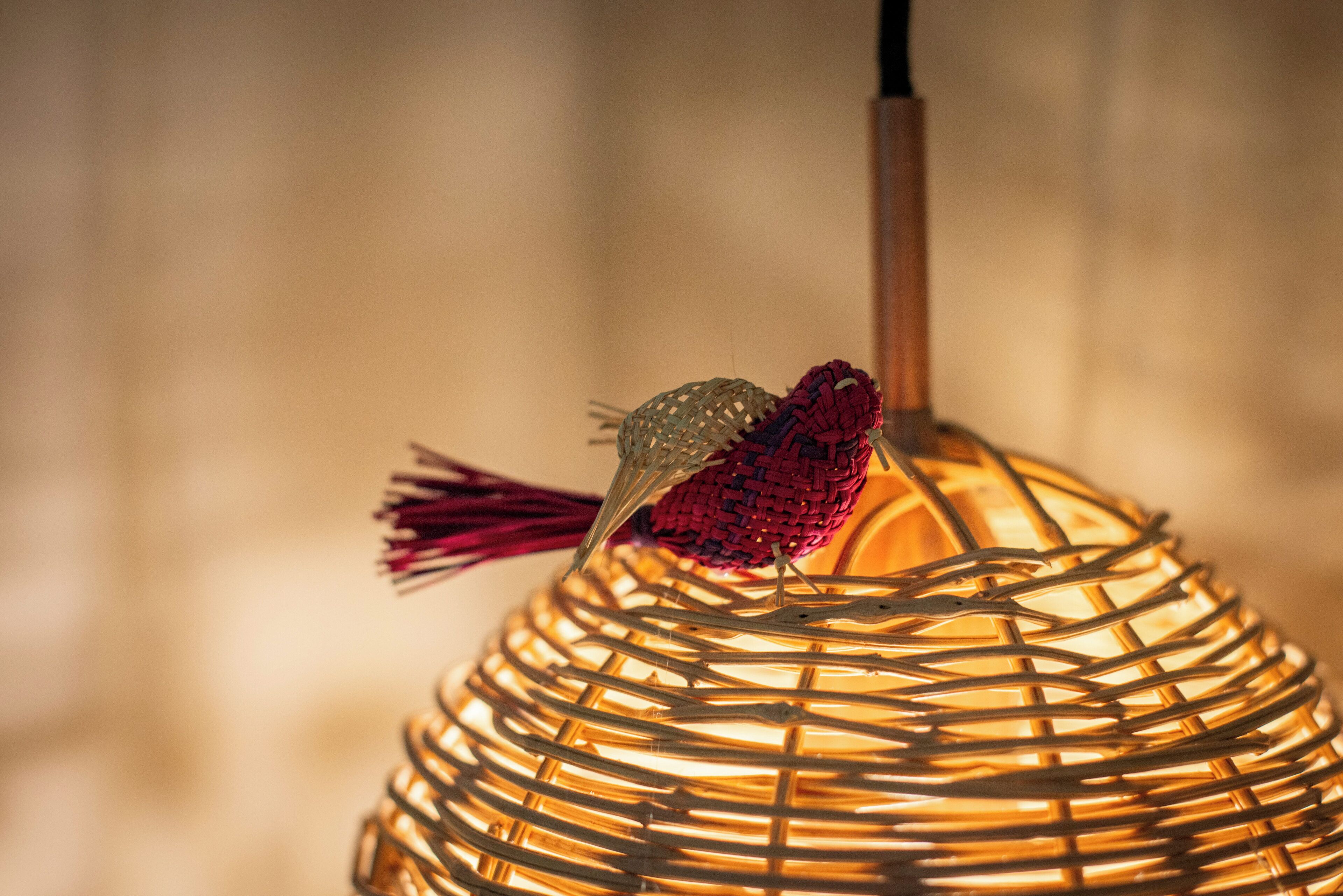 A woven lamp with a tassel hanging from it.