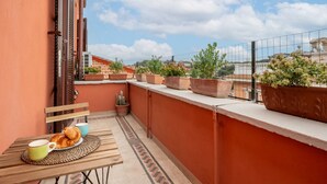 A balcony with a table, chairs, potted plants, and a view of the cityscape. - Top view luxury apartment Piazza del Popolo (Roma)