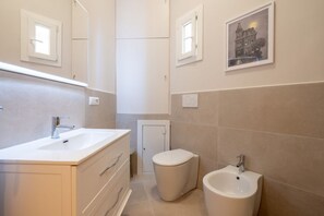 Een douche, een haardroger, een bidet, handdoeken