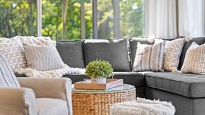 A modern living room with a sectional sofa, a round coffee table, and a small potted plant. - The Cozy Lake House  (Wonder Lake)