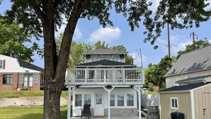 Une maison à deux étages avec un balcon, un garage et une pelouse.