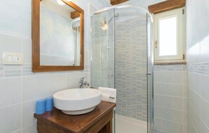 A bathroom with a white sink, wooden vanity, a glass shower enclosure, and a window. - Villa Natura Mikulezi (Labin - Rabac)