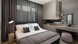 Un dormitorio moderno con cama, mesita de noche, lámpara y un espejo grande.