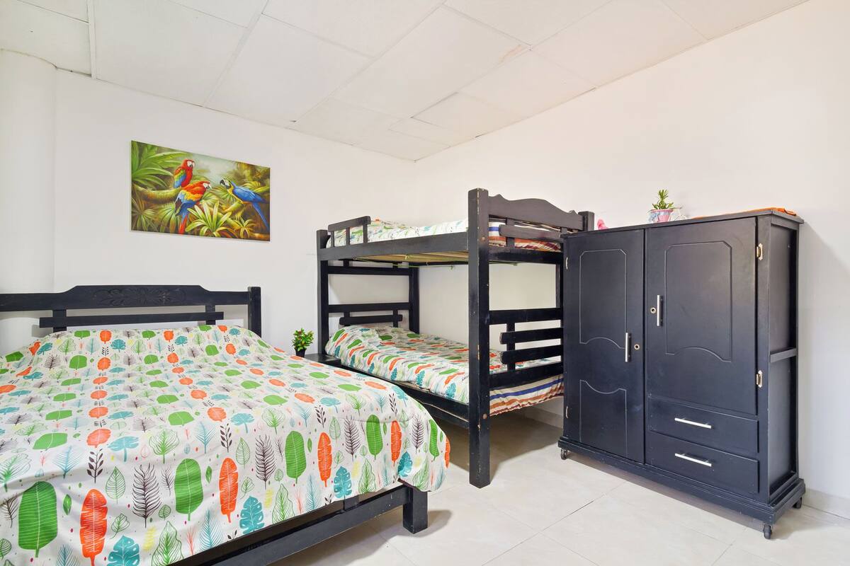 Een kamer met stapelbedden, een kledingkast en een schilderij aan de muur.