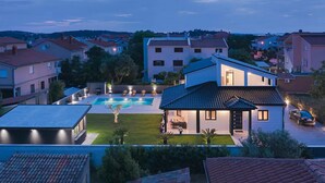 A residential area with a swimming pool, a covered patio, and a view of neighboring houses. - Beautiful home in Pula (Pula)