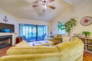 Relax in this cozy living space with a fireplace, comfortable seating, and a large window.