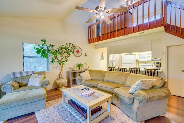 Relax in this inviting living space with a large sofa, armchair, and coffee table.