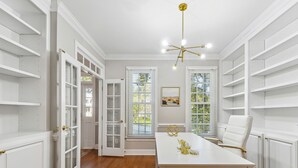 A spacious room with a white table, a white chair, and a chandelier. - Bright Clayton Home with Screened Deck! (Clayton)