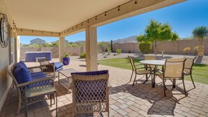 Un patio exterior con muebles de mimbre, una mesa y sillas.