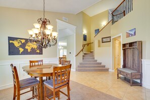 A dining area with a wooden table and chairs, a chandelier, and a world map on the wall. - Arizona Vacation Rental w/ Patio & Grill! (Corona de Tucson)
