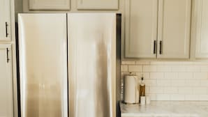 A kitchen with stainless steel appliances, light-colored cabinets, and a marble countertop. - Rims view pet friendly home  (Billings)