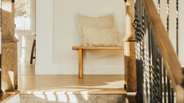 A staircase with wooden railings and carpeted steps leading to a landing with a bench and a framed picture on the wall. - Rims view pet friendly home  (Billings)