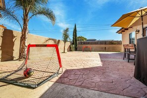 A patio with a soccer goal, outdoor furniture, and a palm tree. - Dreamscape LA - Back House Only (Hawthorne)