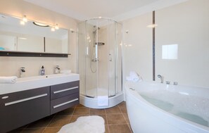 A modern bathroom with a glass-enclosed shower, a large bathtub, and a vanity with a mirror. - Amazing home in Krsan (Krsan)