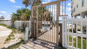 A gated entrance to a private beach area with a sign indicating restricted access.