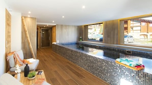 Un baño moderno con una bañera grande, suelo de madera y vistas al exterior.