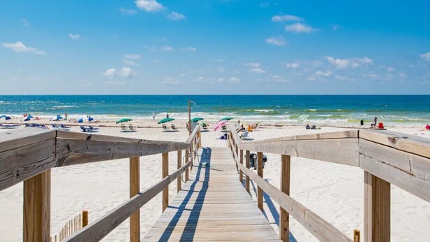 A wooden boardwalk leading to a beach with umbrellas and sun loungers. - Perdido Skye 71 | Beachfront, Pool, Private Balcony | My Beach Getaways (Pensacola)