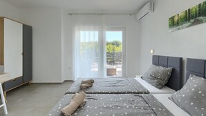 Una camera da letto con un letto, due comodini, un armadio e un balcone con vista.