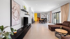 A modern living room with a large abstract painting, a flat-screen TV, a sofa, and a coffee table. - Beautiful home in Porec (Porec)