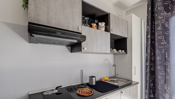 Una cocina moderna con estufa integrada, un lavamanos y armarios superiores.