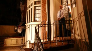 Ein zweistöckiges Gebäude mit einem Balkon und einer Treppe zum Eingang.