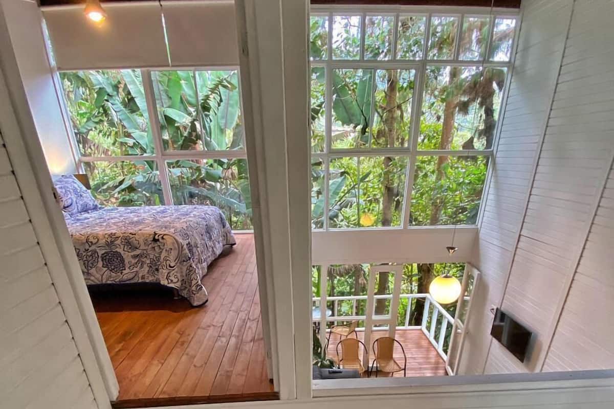 A bedroom with a wooden floor and a bed with a floral bedspread.