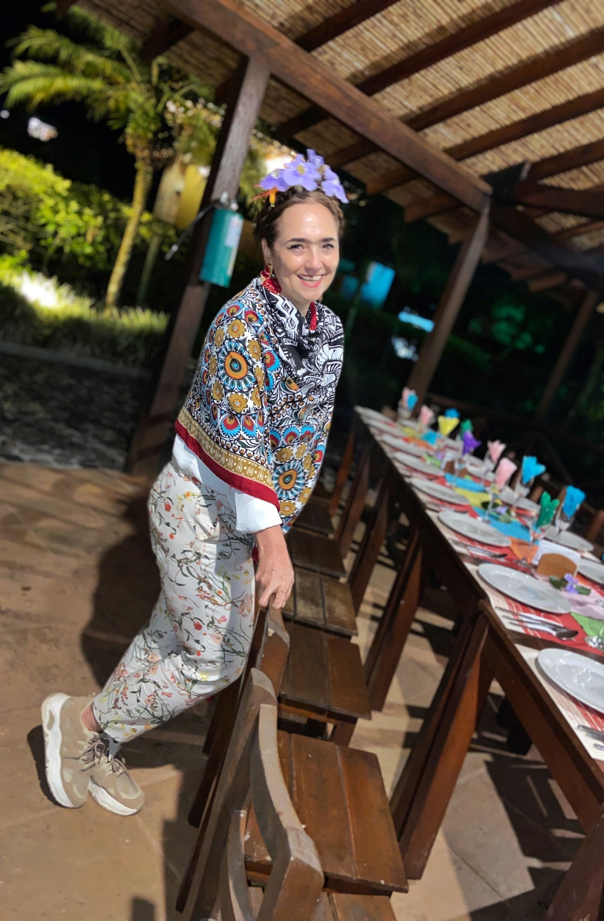Un área de comedor al aire libre techada, con bancos y mesas de madera dispuestas para una comida.