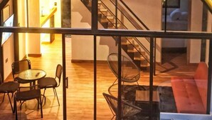 A modern, triangular-roofed structure with a glass facade, wooden flooring, and a staircase leading to an upper level. - Avalon Hotel Campestre en Jardin (Jardin)