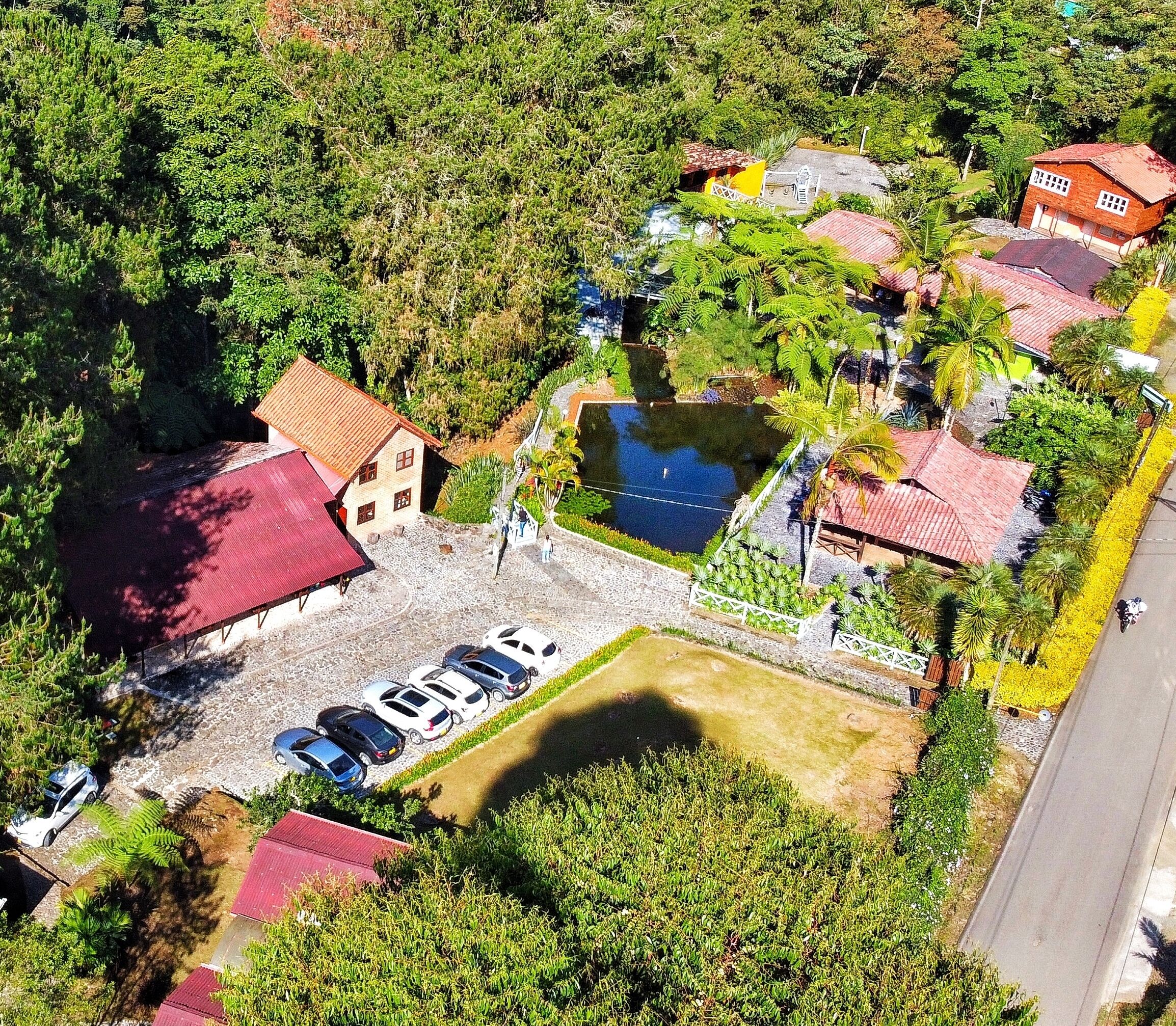 Vista aérea de una zona residencial con casas, piscina y aparcamiento.