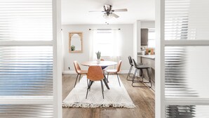 Un espace repas comprenant une table ronde, des chaises et un ventilateur de plafond.