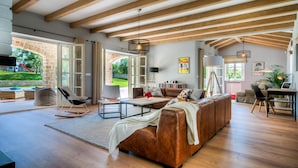 A spacious living room with a large brown leather sofa, a coffee table, and a dining area with a laptop. - Awesome home in Porec (Porec)