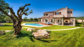 A two-story house with a swimming pool, outdoor seating area, and a stone fireplace. - Awesome home in Porec (Porec)