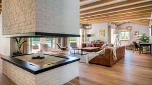 A modern living room with a fireplace, wooden beams, and a cozy seating area. - Awesome home in Porec (Porec)