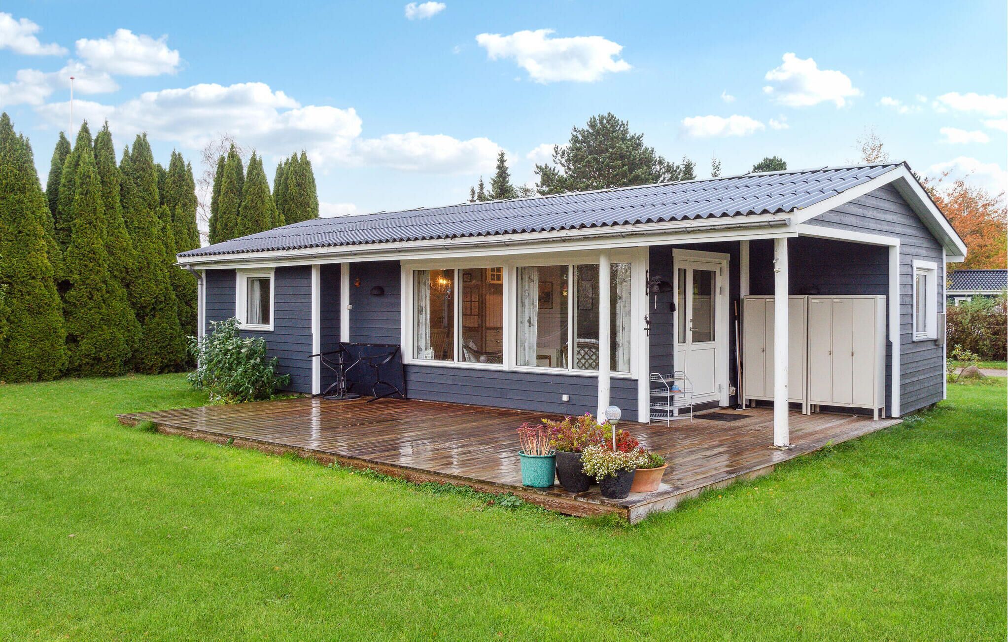 Une maison de plain-pied avec un porche couvert, une terrasse et un garage.