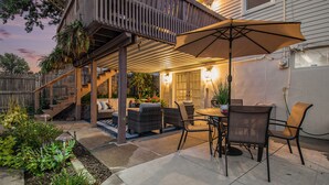 A covered patio with outdoor furniture, a table, and an umbrella.