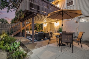 A covered patio with outdoor furniture, a table, and an umbrella.