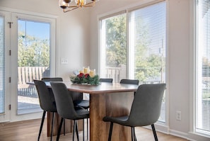 A dining area with a wooden table, six chairs, and a chandelier.