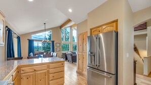 A spacious kitchen with wooden cabinets, a large stainless steel refrigerator, and a central island.