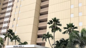 A multi-story hotel with balconies, palm trees, and a sign reading "PLAYA AZUL I". - << NEW >> Completely Renovated, Playa Azul-Tower 1, 17th Floor, 1 Bedroom 1Bath  (Luquillo)