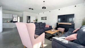 A modern living room with a sectional sofa, a pink armchair, and a coffee table.